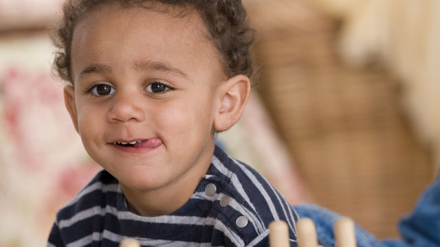 Bebê com a língua no canto da boca