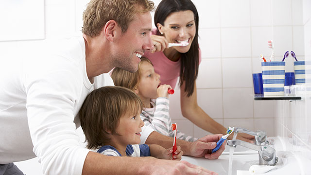 Família no banheiro escovando os dentes