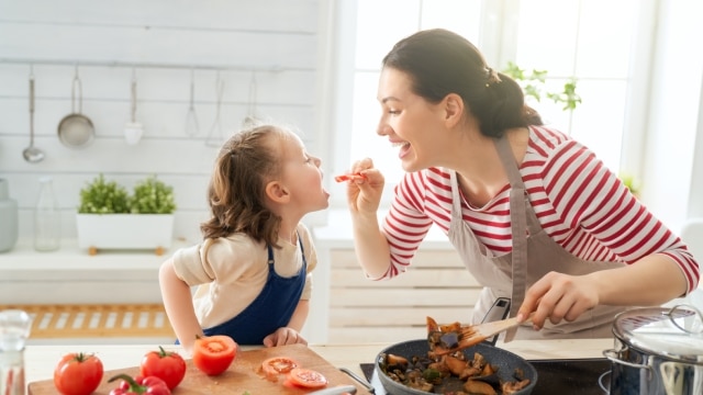 Mãe e filha na cozinha preparando uma refeição com alimentos saudáveis