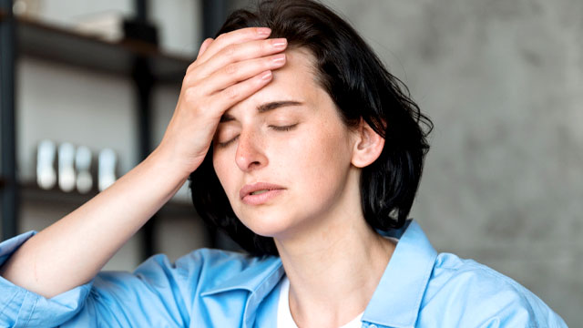 Mulher se perguntando se dor de dente causa dor de cabeça