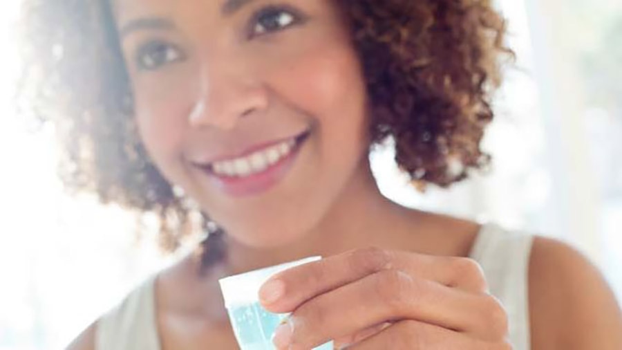 Mulher usando enxaguante bucal natural
