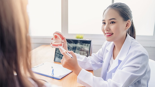 Homem de meia-idade derramando água em um copo de vidro enquanto sorria