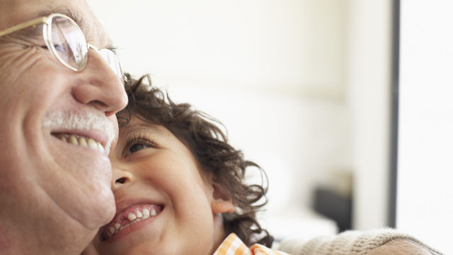 Avô e neto abraçados e sorrindo